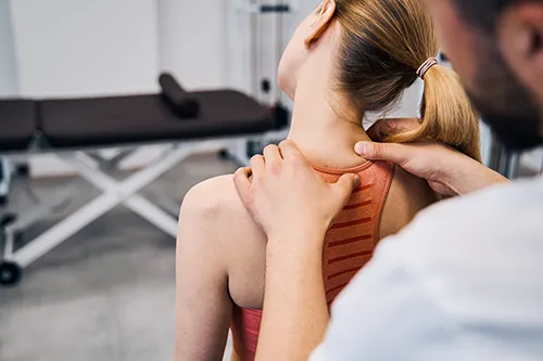 Close up of a chiropractor assessing a patients neck pain