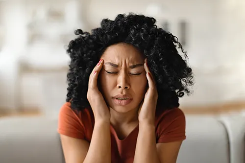 Woman massage her temples due to a headache